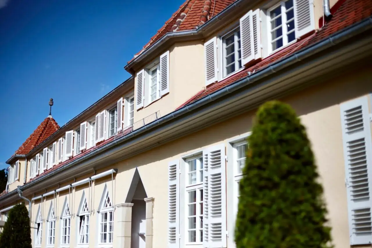 Elegante Hotelaußenansicht mit großzügiger Terrasse und grüner Umgebung.