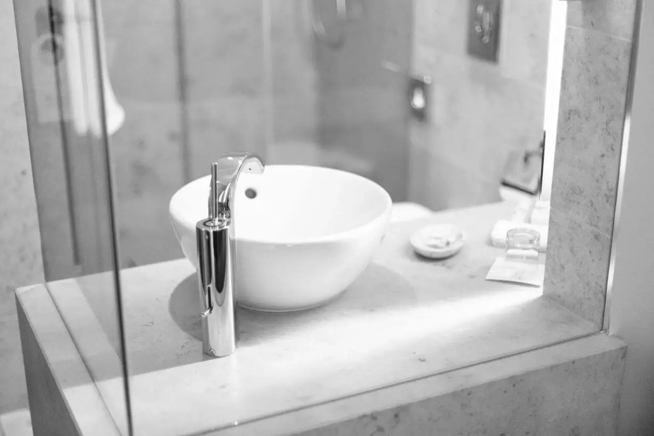 Ein modernes Badezimmer mit runder Waschschüssel, edler Armatur und stilvollem Design.