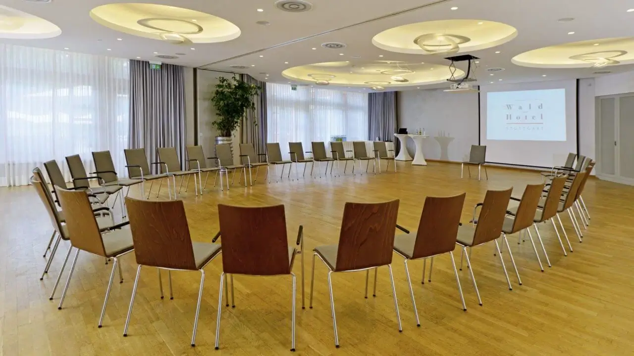 Tagungsraum Stuttgart – Heller Konferenzraum mit Stuhlkreis und Präsentationstechnik.