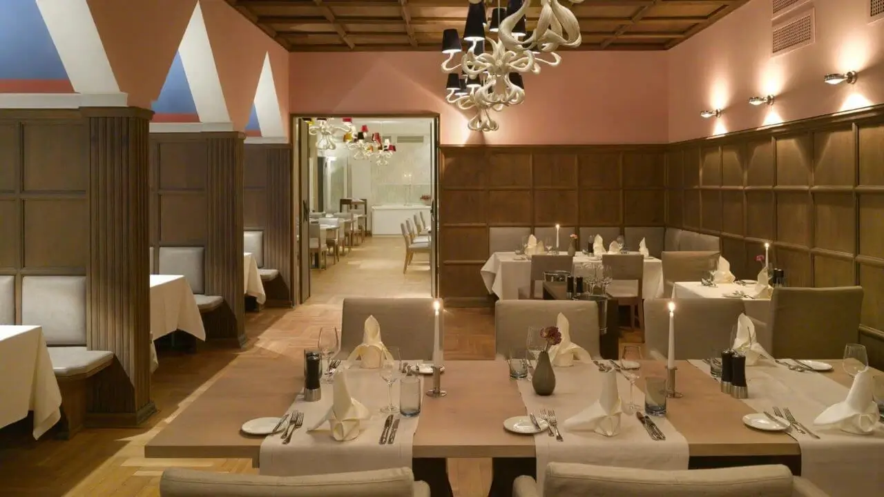 Elegantes Restaurant mit gedeckten Tischen und stilvollem Holzinterieur.